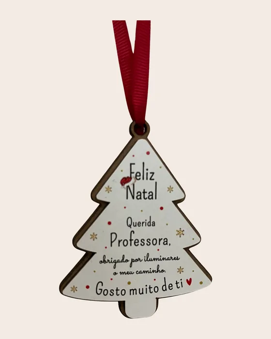 Enfeite de árvore em forma de pinheiro, madeira pintada de branco, com a frase «Feliz Natal, Querida Professora, obrigado por iluminares o meu caminho. Gosto muito de ti», pendurado por fita vermelha.